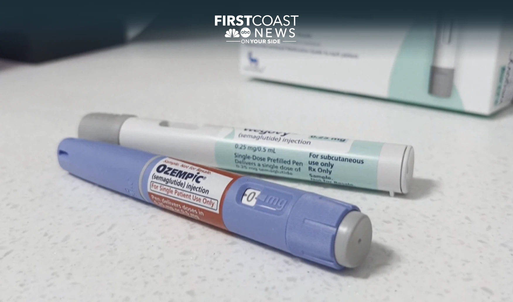 Two Ozempic pens next to their box and dose cartridges